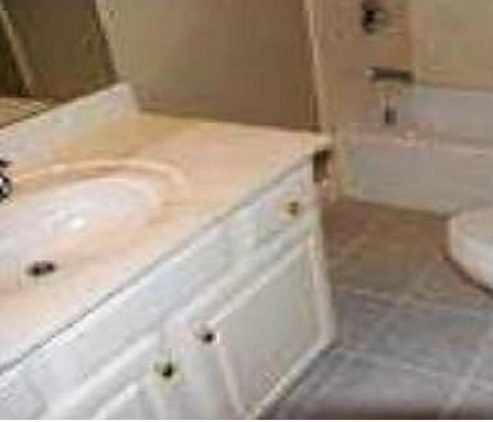 White colored vanity and sink area that is clean and spotless