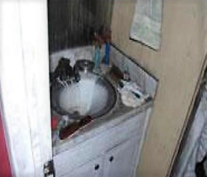 Vanity and sink area, which has soot and ashes from a fire. 
