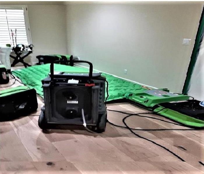 Living room with hardwood floors but with our drying mat system, 1 dehumidifier and a few air movers. 