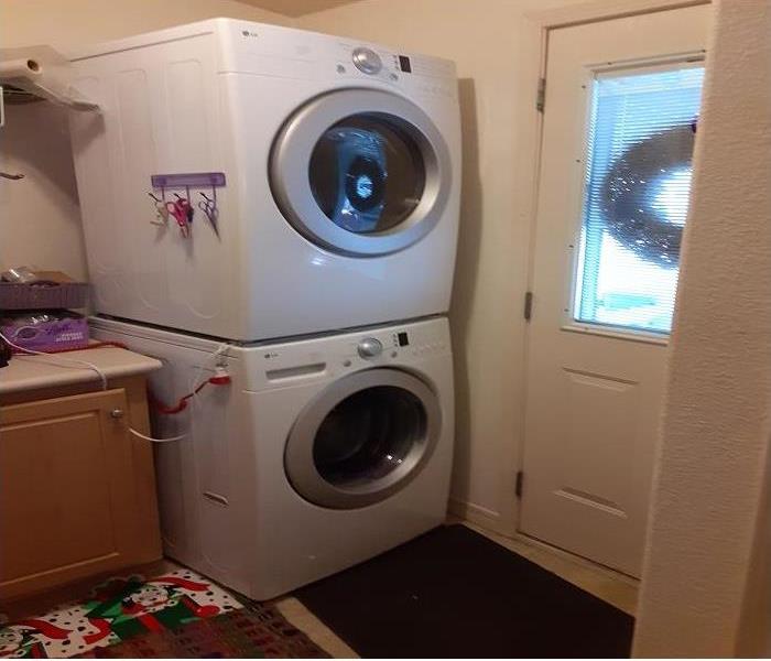 Stackable white colored washer and dryer in the laundry room